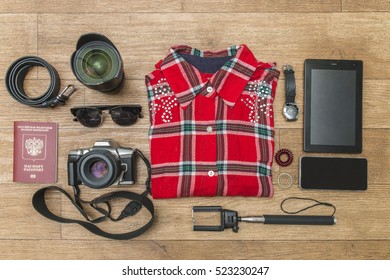 The Concept Of Travel Shirt, Watch, Lens, Strap, Glasses, Camera, Phone, Tablet, Bracelets, Passport, Selfie Stick. Overhead View. Top View. Flat Lay.