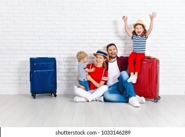 Concept Travel And Tourism. Happy Family With Suitcases Near Empty Wall
