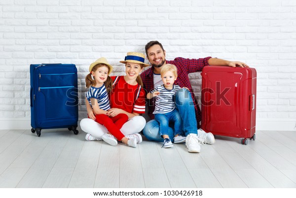 concept travel and tourism. happy family with\
suitcases near empty\
wall\
