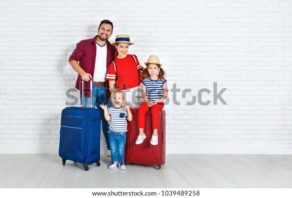 concept travel and tourism. happy family with\
suitcases near empty\
wall\
