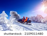 Concept travel tourist group snowmobile tour in frozen forest. Polar arctic snow mountains with sun light.