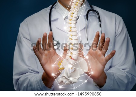 The concept of the treatment of the spine. The doctor produces manipulation with the spine on a blue background.