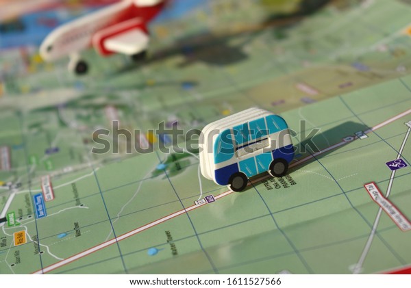 The concept\
of trip for a travel company. toy bus and plane on the map. To\
travel by plane. Choose a country to fly. Tourist destination. Road\
map with the little car. trip\
planning