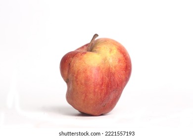 Concept of ugly food - red apple on white background. Image contains copy space