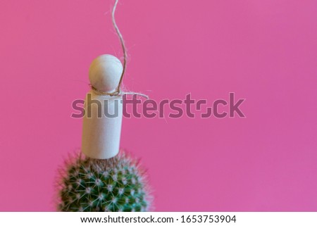 The concept of unbearable pain. Pain leads to suicide.Figurine of a man on needles with a noose around his neck on a pink background. copy space