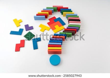 Concept of uncertainty, problem solving, or search for answers. Symbolized by an unsolved colorful block puzzle placed side by side with a question mark crafted from colorful wooden block
