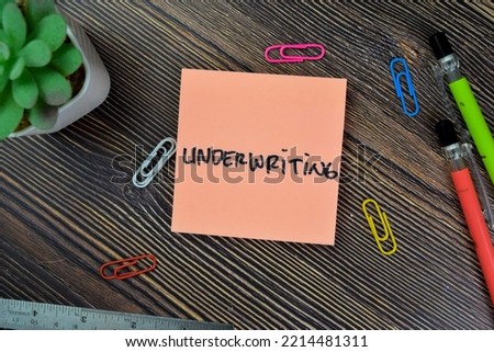 Concept of Underwriting write on sticky notes isolated on Wooden Table.