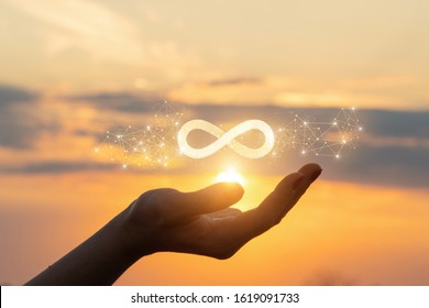 The concept of unlimited Internet. Hand shows the sign of infinity in the sun. - Shutterstock ID 1619091733