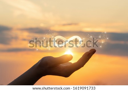 The concept of unlimited Internet. Hand shows the sign of infinity in the sun.