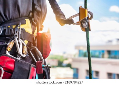 Concept of urban works. Equipment of industrial mountaineer worker on roof of building during industry high-rise work. Climbing equipments before starting job. Rope laborer access. Copy space - Shutterstock ID 2189784227