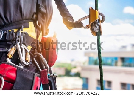 Concept of urban works. Equipment of industrial mountaineer worker on roof of building during industry high-rise work. Climbing equipments before starting job. Rope laborer access. Copy space