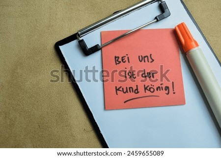 Concept of With us the customer is king write on sticky notes isolated on Wooden Table.