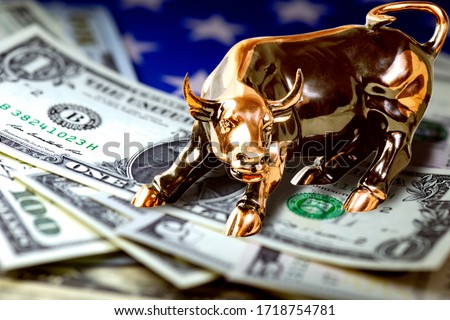 Concept of US money and trading. Us dollar bills and american flag under copper bull. Macro image.