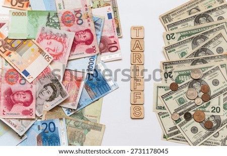 The concept of US trade tariffs in relation to different countries. US dollar bills versus European and Asian money banknotes. New tariffs on goods imported into America. Finance background