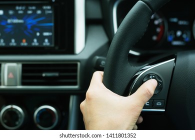 The concept of using hands to press the volume control switch in the car