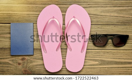 The concept of vacation on the beach, tourism. Summer traveler background. Flip flops, passport, sunglasses on wooden background. Top view. Flat lay