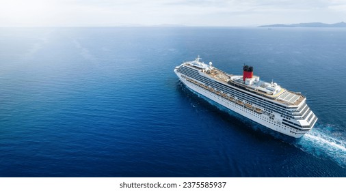 Concept for vacation and travel with a generic cruise ship sailing over the calm ocean with copy space