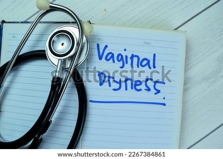 Concept of Vaginal Dryness write on book with stethoscope isolated on Wooden Table.