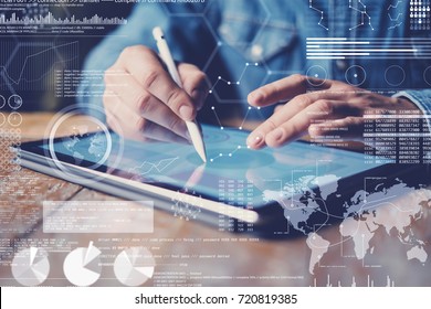 Concept of virtual diagram,graph interfaces,digital display,connections icon.Male hand holding stylus pencil on display of contemporary electronic tablet.Blurred background. Horizontal