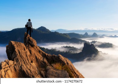 Concept vision, Young businessman wearing comfortable casual suit jacket standing holding business bag on top of peak mountain and looking forwards, success, competition and leader concept. - Shutterstock ID 1174270672