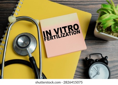 Concept of in vitro fertilization write on sticky notes with stethoscope isolated on Wooden Table.