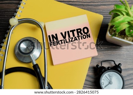 Concept of in vitro fertilization write on sticky notes with stethoscope isolated on Wooden Table.