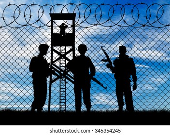 Concept Of War. Silhouette Of Military Guards Near The Fence And Watchtower