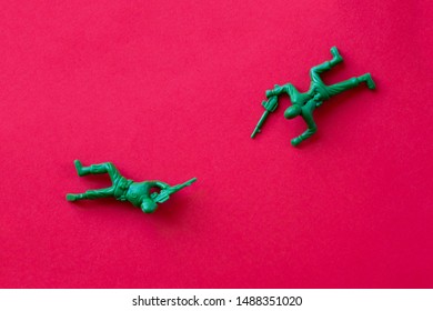 Concept war. Two plastic soldiers facing each other, isolated, top view, red background. - Powered by Shutterstock