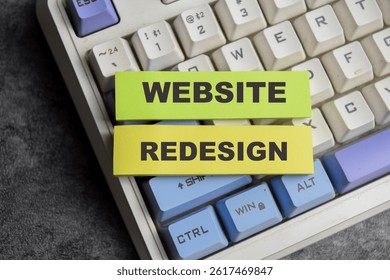 Concept of Website redesign write on sticky notes isolated on Wooden Table.