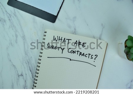 Concept of What Are Surety Contracts? write on a book with statistics isolated on Wooden Table.