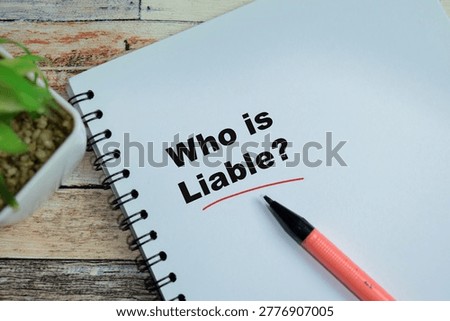 Concept of who is liable write on book isolated on Wooden Table