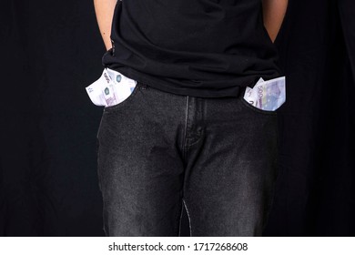 A Concept Without Money. A Man Shows Empty Pockets. No Money For Karate And Self-isolation. A Man Stands On A Black Background And Holds His Hands Behind Him