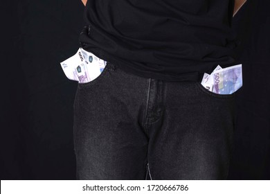 A Concept Without Money. A Man Shows Empty Pockets. No Money For Karate And Self-isolation. A Man Stands On A Black Background And Holds His Hands Behind Him