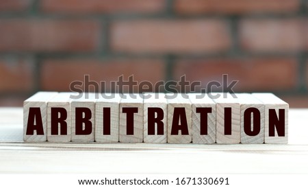 concept word arbitration on cubes against the background of a brick wall