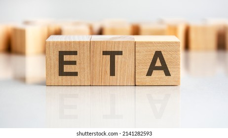 concept word ETA on wooden cubes on a gray background. inscription on a financial, business or economic theme. ETA - short for Estimated Time Of Arival