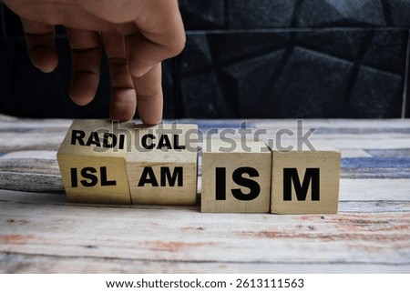 Concept word Radicalism or Islamism, turns cube and changes the word radicalism to islamism on wooden blocks on a wooden table