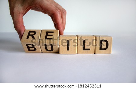 Concept word 'rebuild' on cubes on a beautiful wooden table. Male hand. White background. Business concept. Copy space. Stockfoto © 