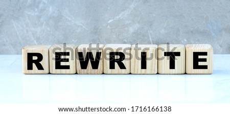 concept of the word REWRITE on cubes on a gray background. Business concept.