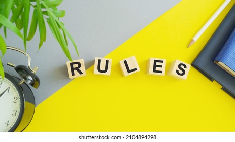 Concept word RULES on wooden cubes on a gray yellow background. Business concept, Top view flat lay. - Shutterstock ID 2104894298