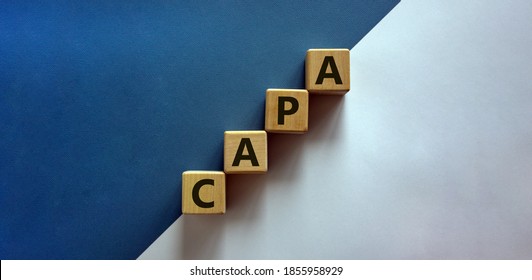 Concept words 'CAPA, corrective and preventive actions' on wooden cubes on a beautiful white and blue background. Business concept. Copy space.