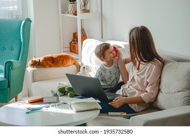 Concept of work at home and home family education, mother working with laptop at home, child playing nearby