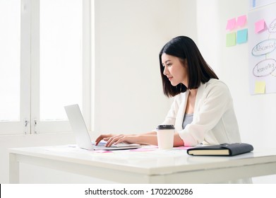 Concept Of Work From Home. Young Asian Business Woman Working On Computer Laptop In Office Room With Paperwork Document On Desk