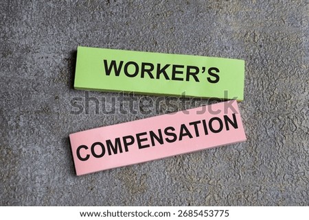 Concept of worker's compensation write on sticky notes isolated on Wooden Table.