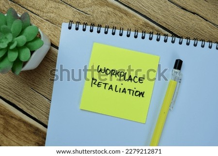 Concept of Workplace Retaliation write on sticky notes isolated on Wooden Table.