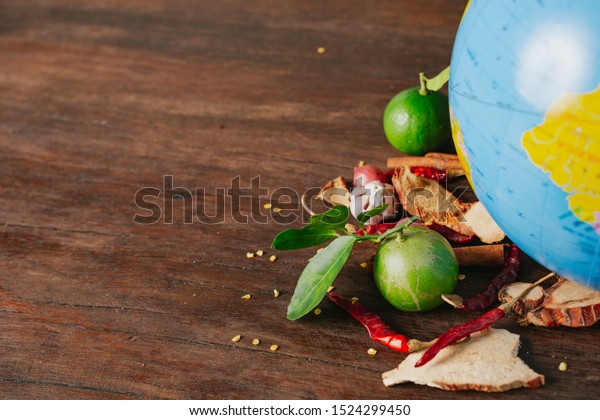 The\
concept of World Food Day, a car-packed spice and fresh colors\
placed on a simulated globe on a brown wooden\
floor.