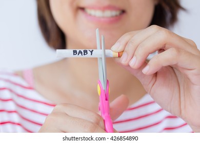 Concept : World No Tobacco Day. Woman Are Use Kids Scissors Cutting Tobacco With The Word Baby And De-focus She Smile. Mom Decided To Quit Smoking To Child.