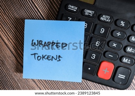 Concept of Wrapped Tokens write on sticky notes isolated on Wooden Table.