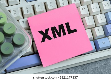 Concept of XML - Extensible Markup Language write on sticky notes isolated on Wooden Table.