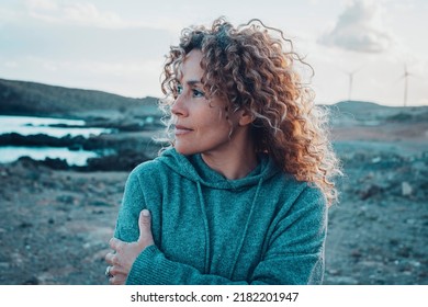 Concept of young woman and emotions. Inner balanced portrait of female enjoying freedom and sensations outdoor. Travel and wanderlust lifestyle people. Beautiul lady with curly long hair smiling - Powered by Shutterstock