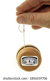 Concept of yoyo bathroom scale held in hand close up on white background